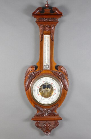 An Edwardian aneroid barometer and thermometer with 18cm porcelain dial contained in a carved walnut case 97cm h x 33cm w 