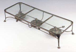 An Edwardian silver plated plate warmer with glass top and 3 burners on scroll feet 66cm 