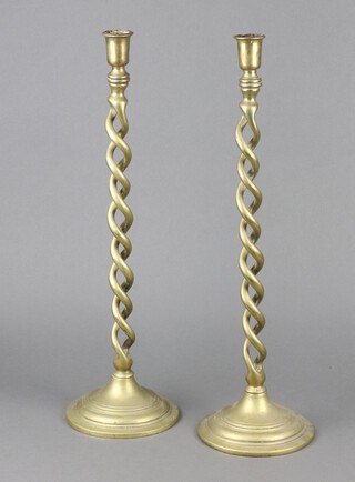 A pair of 19th Century brass spiral turned candlesticks raised on a circular base 52cm 