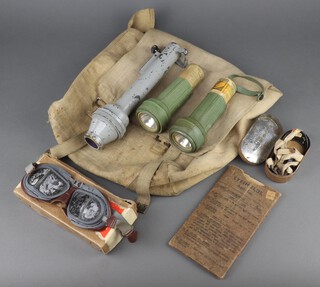 A Santon Ltd. signalling torch, two FF Lam torches, a pair of Mk.3 anti gas goggles, 2 other pairs of goggles contained in a webbing haversack 