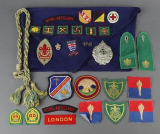 An Argyle and Sutherland Highlanders cap badge together with a quantity of Scouts cloth insignia 