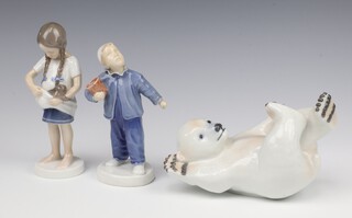 A Royal Copenhagen figure of a polar bear cub 537 16cm, ditto of a standing boy 2251 16cm and a girl 1779 16cm