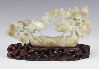 A jade carving of 2 exotic birds  beneath flowering  fruit trees 21cm, on a hardwood stand  