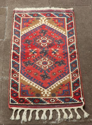 A red, white and blue ground Afghan rug with 2 diamond medallions to the centre 128cm x 71cm 