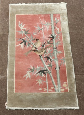 An oatmeal and pink ground Chinese rug decorated birds amidst bamboo 124cm x 61cm 