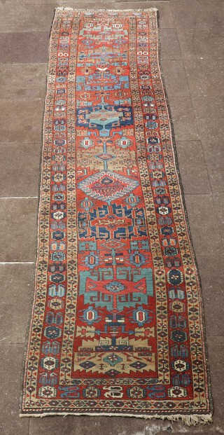 A Caucasian style brown and blue ground runner with stylised medallions to the centre within a multi row border 378cm x 89cm 