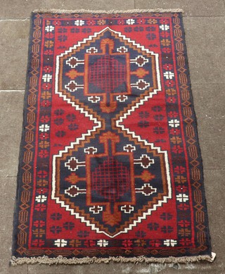 A red, black and white ground Belouche rug with 2 diamonds to the centre 145cm x 83cm 