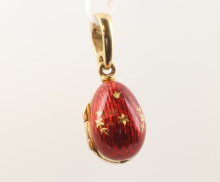 A Faberge 18ct yellow gold limited edition red guilloche enamel egg pendant with diamond set heart pendant to the interior no.305/500, 25mm, 5.1 grams 