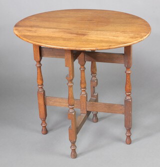 A 1920's oak oval coaching table raised on turned and block supports 70cm h x 75cm w x 59cm d 