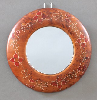 A circular plate mirror contained in an Eastern hardwood and inlaid floral patterned frame 26cm diam. 