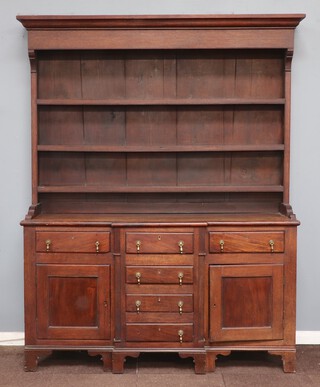 A Georgian oak and mahogany break front dresser, the associated plate rack with moulded cornice fitted 3 shelves, the base fitted 5 drawers with brass drop handles and double cupboard 215cm h x 166cm w x 46cm d 