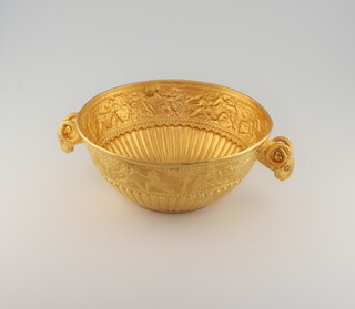 A byzantine style yellow gold cup, testing as 22ct, with demi fluted body and a scroll of dancing figures, rams head handles with diamond set eyes, 10cm, 57.3 grams 