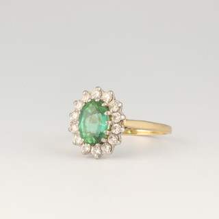 A yellow gold, testing as 18ct oval green gem stone and diamond cluster ring, the centre stone approx. 1.5ct surrounded by 14 brilliant cut diamonds, each approx. 0.03ct, 4.6 grams, size P 1/2