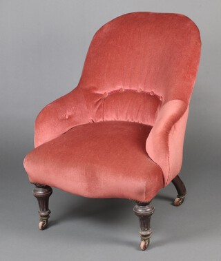 A Victorian metal framed tub back chair upholstered in pink buttoned material, raised on turned and fluted supports 81cm h 