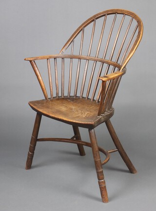 A 19th Century elm comb back Windsor chair, raised on outswept supports with Crinoline stretcher 97cm h x 64cm h x 34cm w (seat 30cm x 23cm), the base with Spillman & Company label, St Martins Lane, London  