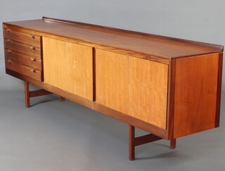 In the manner of Archie Shine, a mid-Century teak sideboard with raised back, fitted 4 drawers to the side and with pair of double cupboards enclosed by panelled doors, raised on shaped supports 81cm h x 244cm w x 45cm d 