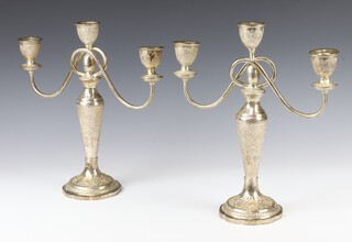 A pair of Iranian silver 3 light candelabra, the repousse decoration with scrolls and flowers 33cm, 1508 grams 