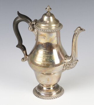 A silver baluster coffee pot with acanthus decoration and engraved inscription, having an ebony handle London 1912, 488 grams, 23cm 