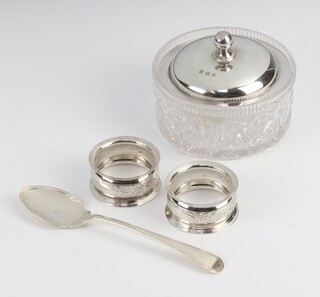 A silver mounted cut glass bowl, 2 napkin rings and a preserve spoon, weighable silver 88 grams 