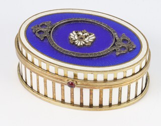 A Russian silver gilt and enamelled oval pill box decorated with a double headed eagle and blue guilloche enamelled lid, with 2 colour sides and ruby push button,  bearing a mark, 84 and AH, 7cm, 174 grams, boxed