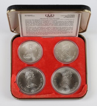 A set of 4 1976 uncirculated Olympic coins, 2 five dollars and 2 ten dollars, 146.5 grams, cased