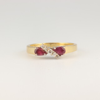 An 18ct yellow gold diamond and ruby crossover ring, size M 1/2, the 5 diamonds each approx. 0.01ct, the 2 pear cut rubies 0.2ct, 3.2 grams 