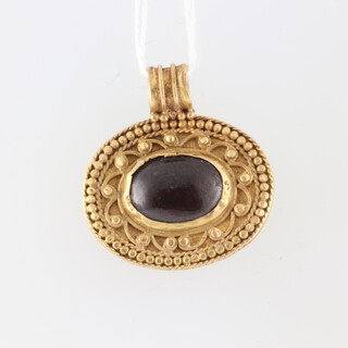 A yellow gold, testing as 22ct, Roman style oval pendant set with a cabochon ruby 10mm x 15mm, 5.8 grams 