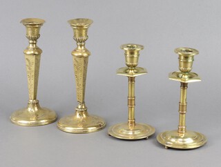 A pair of 19th Century brass candlesticks with octagonal sconces and circular bases 19cm x 10cm and 1 other engraved pair 23cm x 11cm 