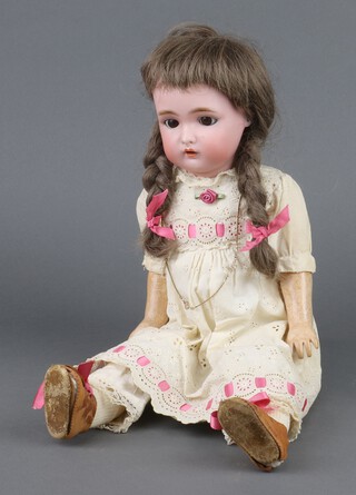 Kammer and Reinhardt, Simon and Halbig a bisque headed doll (circa 1920's), with mouth open, fixed eyes, blonde hair, composite articulate limbs, Halbig marked to head K*R, dressed in a pink and lace dress