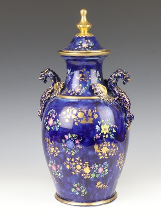 A Continental Chinese style blue ground vase with floral and gilt decorations, having twin dragon handles and cover 44cm 