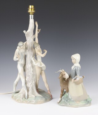 A Lladro figure of a girl standing beside a goat 22cm together with a table lamp with 2 ballet dancers beside a tree 37cm 