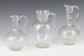 An Edwardian engraved glass jug 23cm, 2 glass ewers 