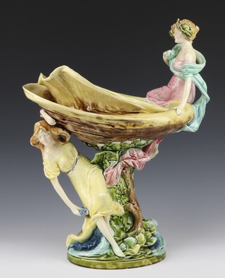 A Continental Majolica bowl in the form of a lady holding a shell above her with a lady sitting on the rim, impressed mark 10507/12, 47cm 