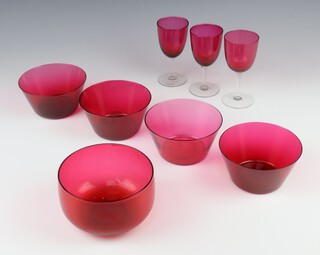 Three cranberry glass sherry glasses and 5 bowls