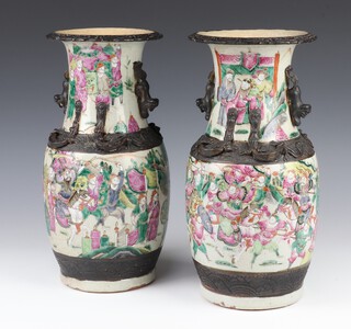 A pair of early 20th Century baluster vases decorated with warriors and having dragon handles, 35cm 