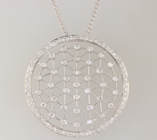 A white gold, stamped 750, circular pierced pendant set with 37 diamonds, each approx. 0.03ct, the outer edge surrounded by brilliant cut diamonds, 45mm, hung on a ditto 38cm chain, gross weight 15.5 grams 