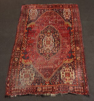 A pink, green, orange and black ground Afghan rug with central medallion within a multi row border 256cm x 162cm 