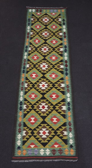 A green, brown and black ground Maimana Kilim rug with all over geometric design 291cm x 79cm 