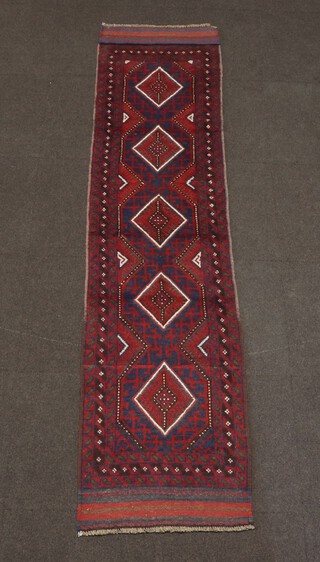 A blue, red and white ground Meshwani runner with 5 diamonds to the centre within a multi row border 238cm x 59cm 