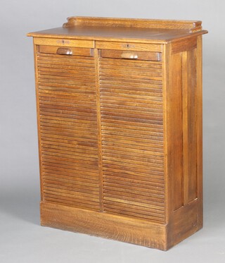 An Edwardian oak double filing chest with 3/4 gallery fitted 18 filing trays enclosed by a tambour shutter, complete with key, 121cm h x 93cm w x 48cm d 