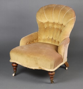 A Victorian metal framed armchair upholstered in gold buttoned material, raised on turned supports with brass caps and casters 74cm h x 58cm w x 58cm d (seat 28cm x 35cm) 