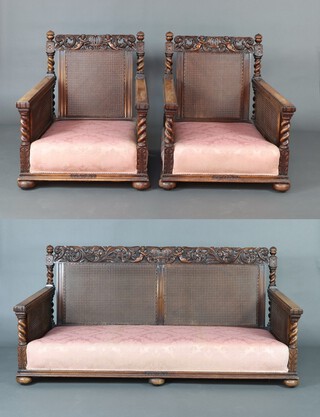 A 1930's Rococo style carved and pierced walnut bergere suite comprising 2 seat settee 84cm h x 182cm w x 86cm d (seat 160cm x 71cm) and 2 matching armchairs 82cm h x 88cm w x 69cm d (seats 50cm x 50cm), the sides with double cane panels, the backs with single cane panels 