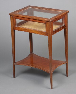 An Edwardian rectangular inlaid mahogany bijouterie table with glass panel to the top,  raised on square tapered supports with shaped undertier 75cm h x 50cm w x 37cm d 