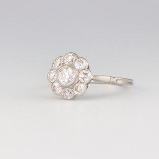 An Edwardian platinum 9 stone diamond daisy ring, approx 1.3ct total, size Q, 3.9 grams 