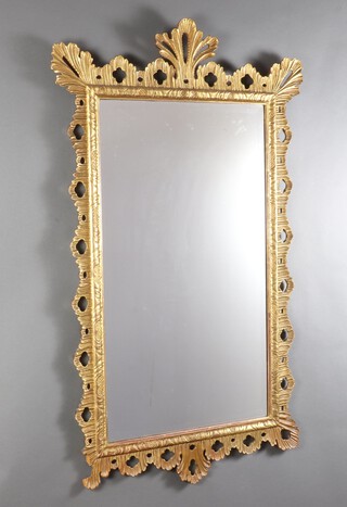 A 19/20th Century rectangular bevelled plate wall mirror contained in a decorative pierced gilt wood frame 138cm h x 83cm w 