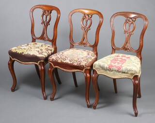 A set of 3 Victorian walnut spoon back dining chairs with pierced splat backs and over stuffed seats, raised on cabriole supports 84cm h x 44cm w x 38cm d (seats 27cm x 23cm) 