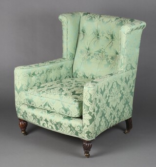 A William IV wing armchair upholstered in green material, raised on turned supports 89cm h x 76cm w x 48cm d (seat 38cm x 38cm) 