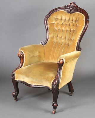 A Victorian carved mahogany show frame armchair upholstered in yellow buttoned material, raised on cabriole supports supports 110cm h x 65cm w x 54cm d (seat 30cm x 31cm) 