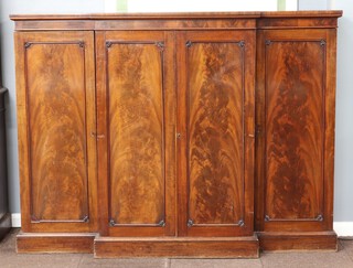 Miles and Edwards, 134 Oxford Street London, a Victorian mahogany breakfront press cabinet, the centre section fitted a tray flanked by pair of cupboards fitted 10 short drawers, enclosed by panelled doors 137cm h x 184cm w x 72cm d 