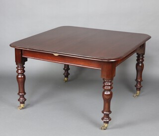 A Victorian mahogany extending dining table raised on turned supports, brass caps and casters 76cm h x 115cm  x 118cm 